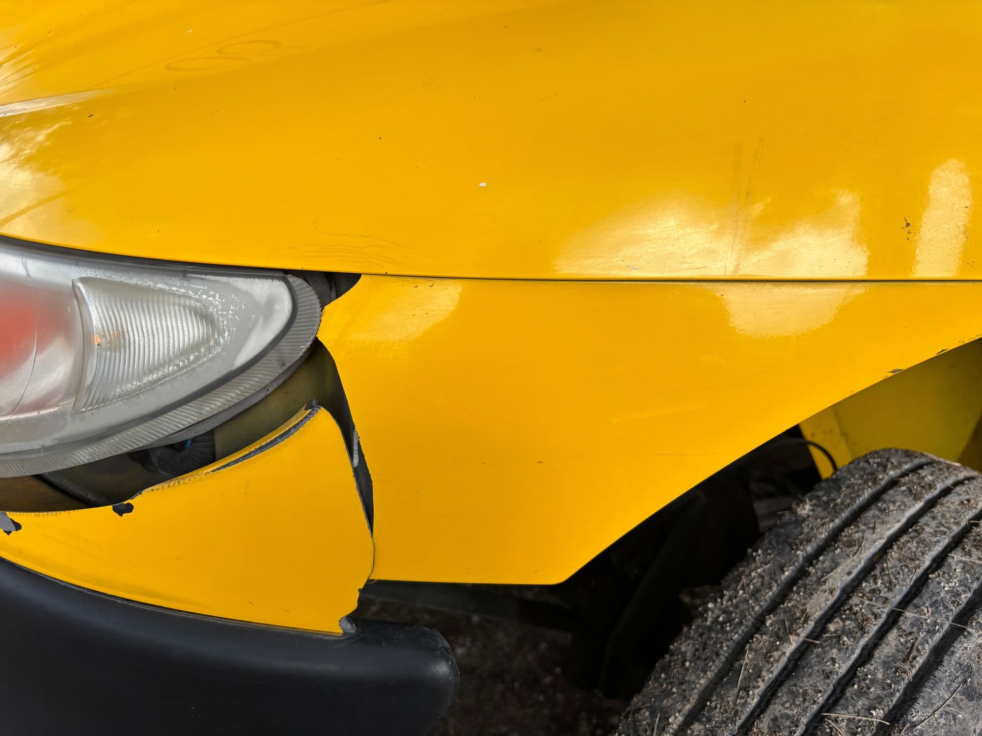 Gele auto met een gedeukte bumper